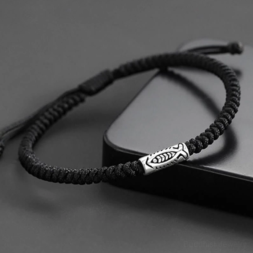 Black koi fish bracelet on male wrist with pinstripe shirt displaying minimal silver bead accent for professional look
