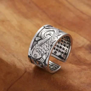 Koi fish heart sutra carved copper ring, 3/4 side view showing detailed fish carving and inner sutra text on adjustable open band