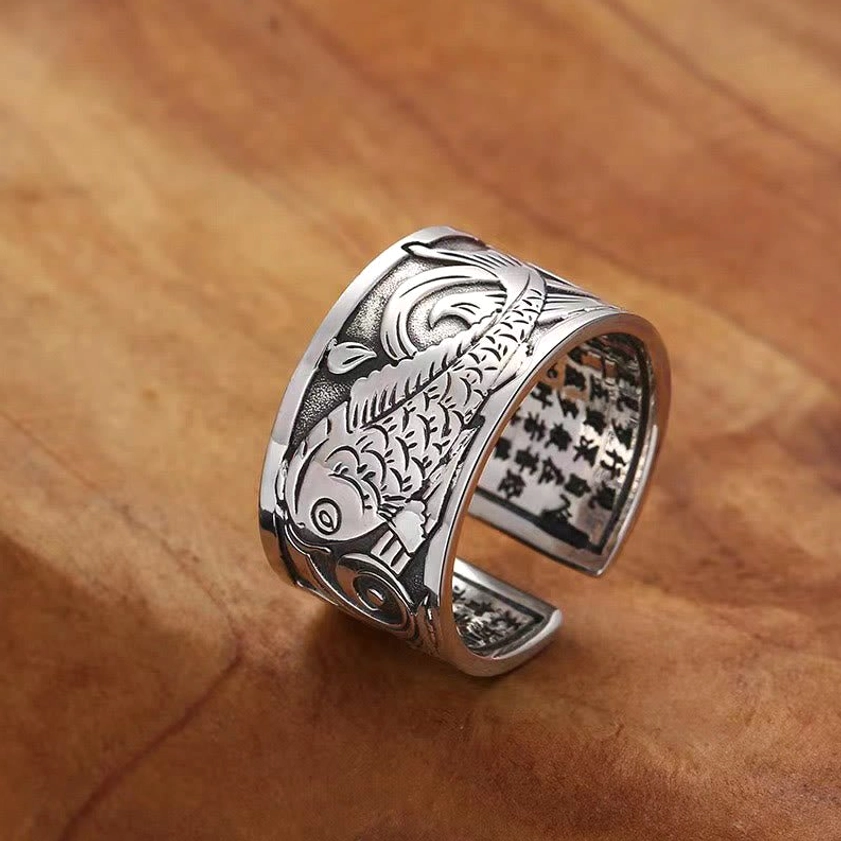 Koi fish heart sutra carved copper ring, 3/4 side view showing detailed fish carving and inner sutra text on adjustable open band