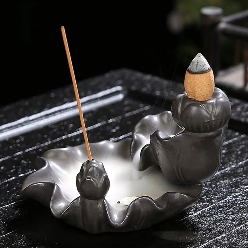 Side view of handcrafted ceramic koi fish incense holder with small white koi and stick incense detail