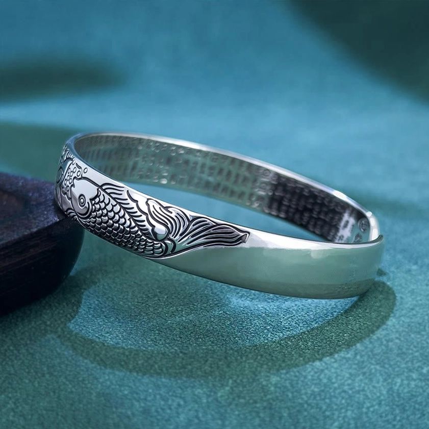 Front oblique angle of koi fish lotus themed copper open cuff bracelet with polished silver finish