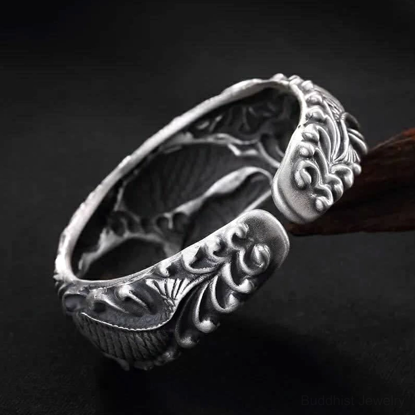 Handcrafted open-ended silver cuff bracelet with vintage carved design and wood background
