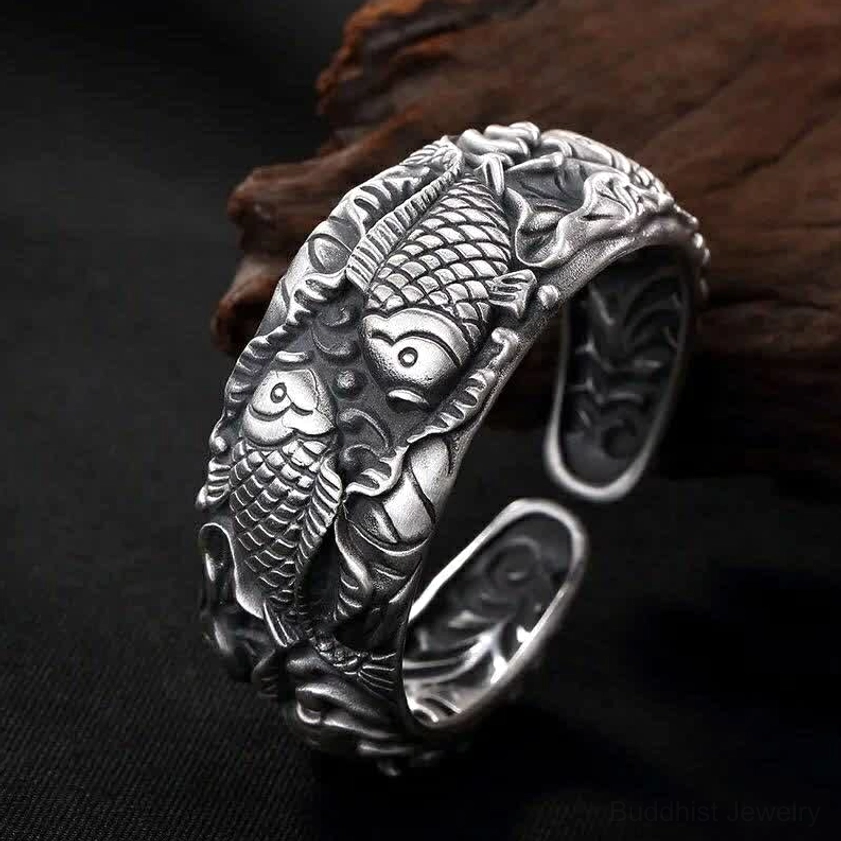 Vintage silver koi and lotus cuff bracelet side view showing carved embossed details and aged patina