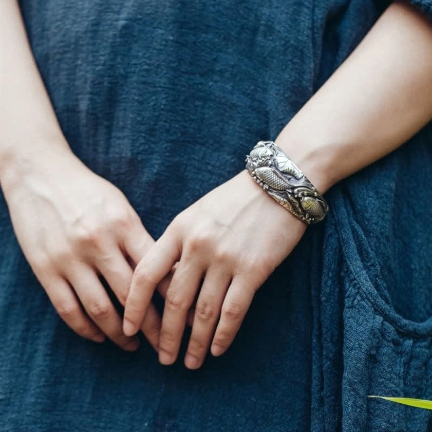 Model wearing koi fish lotus silver prosperity bracelet on left wrist casual styling