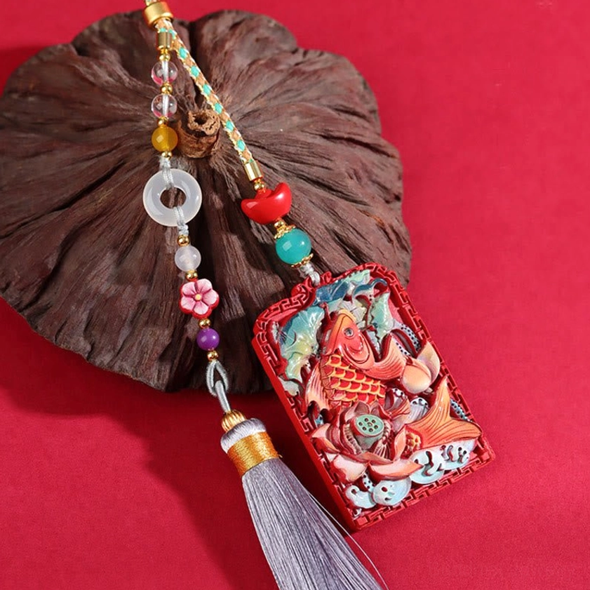 Koi lotus cinnabar car hanging decoration with beaded cord and tassel on dark wood decor and red background