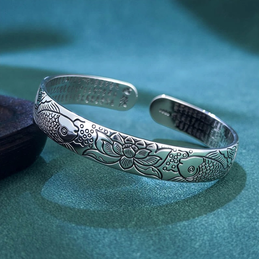 Heart Sutra Koi Fish Lotus copper open adjustable bracelet with laser engraved Buddhist symbols displayed on teal velvet background