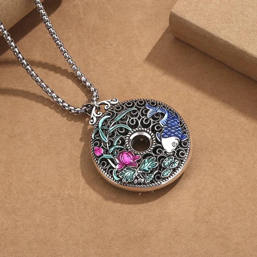 Koi fish lotus peace buckle Buddhist pendant - three-quarter angle view highlighting filigree metalwork and enamel detail on decorative kraft paper background