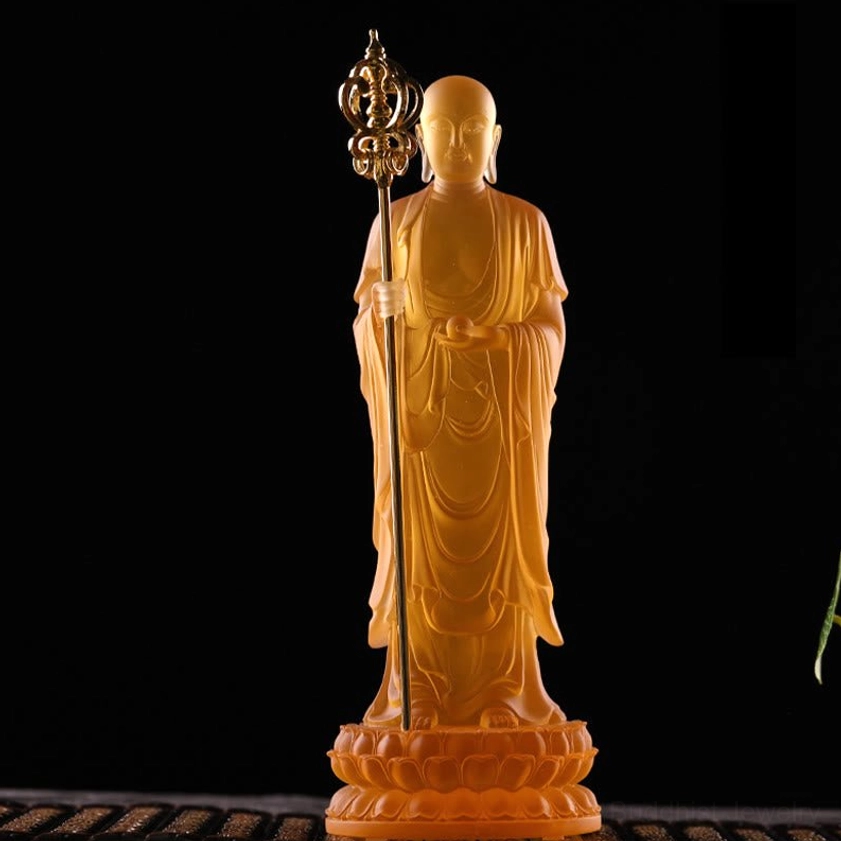 Front view of amber Ksitigarbha Bodhisattva liuli crystal figurine with lotus pedestal on dark background
