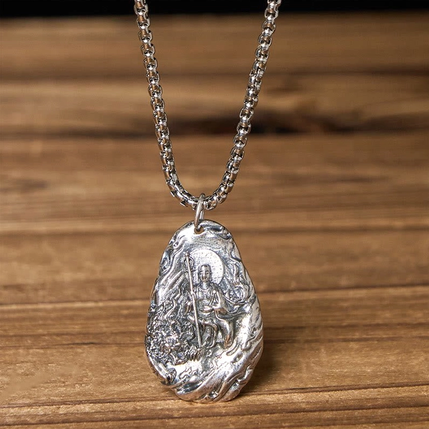 Ksitigarbha Bodhisattva pendant full front carved design with silver metal curb chain on wooden table