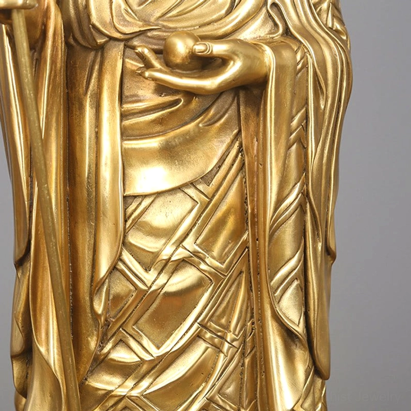 Ksitigarbha Bodhisattva torso close-up showing embossed robe texture, hand holding wish pearl, polished copper finish
