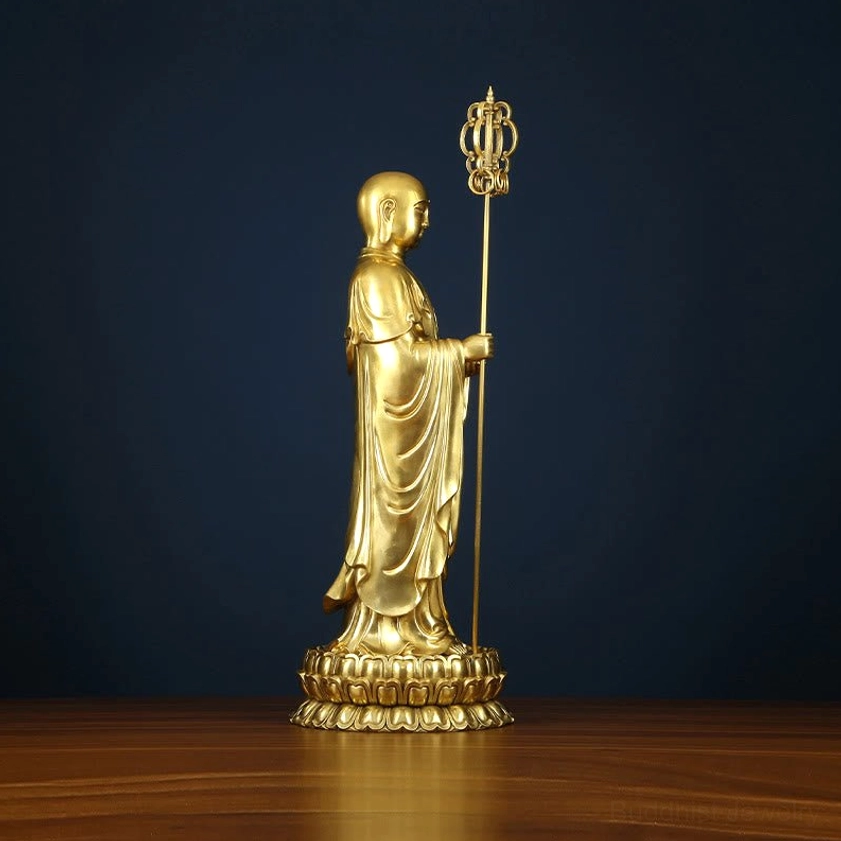 Ksitigarbha Bodhisattva statue rear three-quarter view showing back of monastic robe and handheld dharma staff