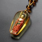 Amber Ksitigarbha Buddha standing liuli crystal pendant necklace with gold-plated Buddha figure and khakkhara staff, oblique top view