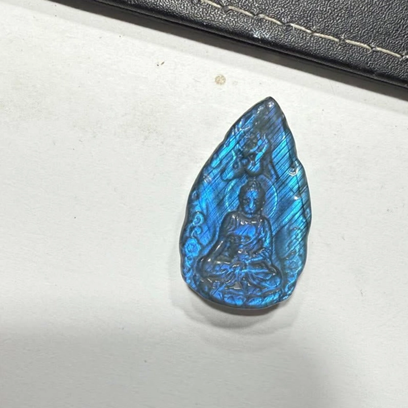 Carved labradorite Buddha statue displaying unique iridescent color variations, showcasing natural labradorescence and authentic hand-carved workmanship