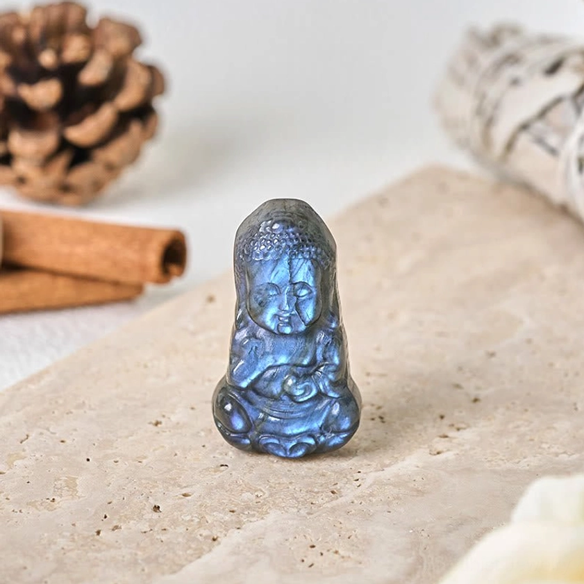 Three-quarter angle view of natural labradorite Buddha figurine showing blue labradorescence with bohemian decor
