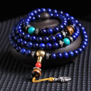 108 bead lapis lazuli mala bracelet with tiger eye turquoise and silver accents displayed on ceramic incense holder - Buddhist prayer beads