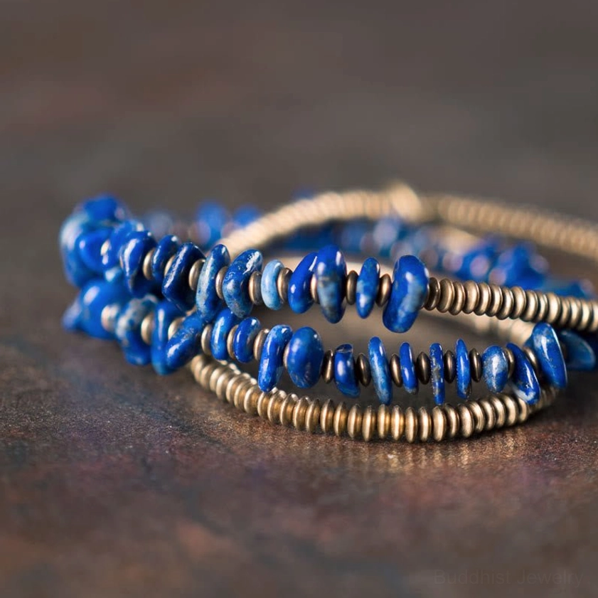Top-down close-up of lapis lazuli stacked three-layer wrap bracelet showing blue stone chip texture and bronze beads