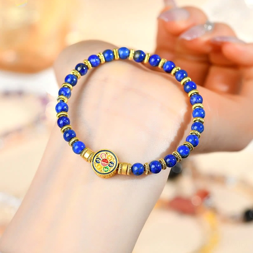 Woman wearing lapis lazuli Buddhist bracelet with hand display of blue stone beads and gold accents