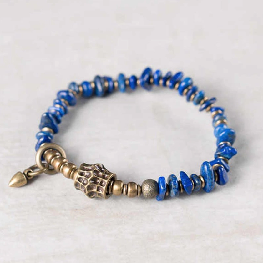 Lapis lazuli irregular bead Buddhist bracelet with classic vintage metal toggle clasp on plain off-white background