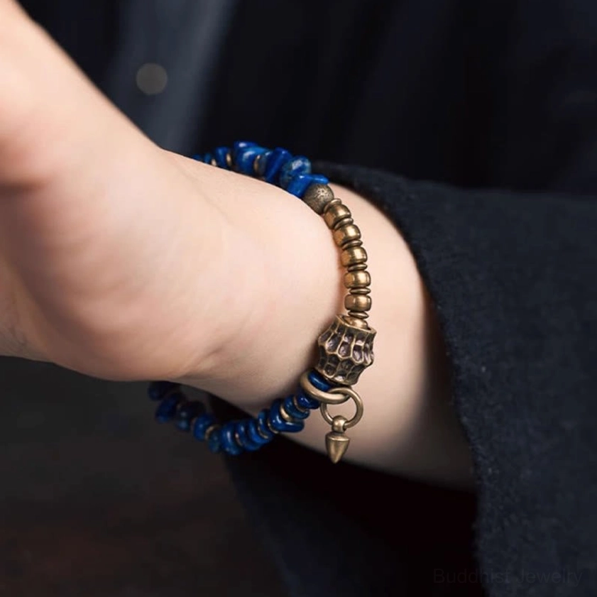 Premium lapis lazuli Buddhist bracelet with vintage metal accents and elastic string on neutral display surface