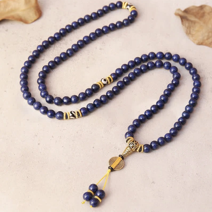 Flat lay view of 108 bead lapis lazuli mala necklace with gold metal clasps and components
