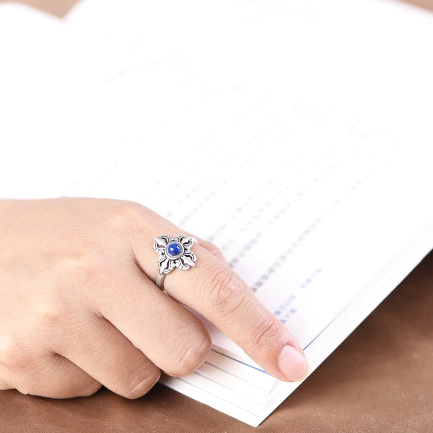 Buddhist ring being worn on index finger, daily wear demonstration with natural silver patina on wooden desk