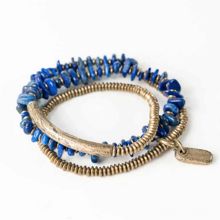 Left side view of handmade lapis lazuli triple wrap bracelet with bronze metal beads and hanging tag on white background