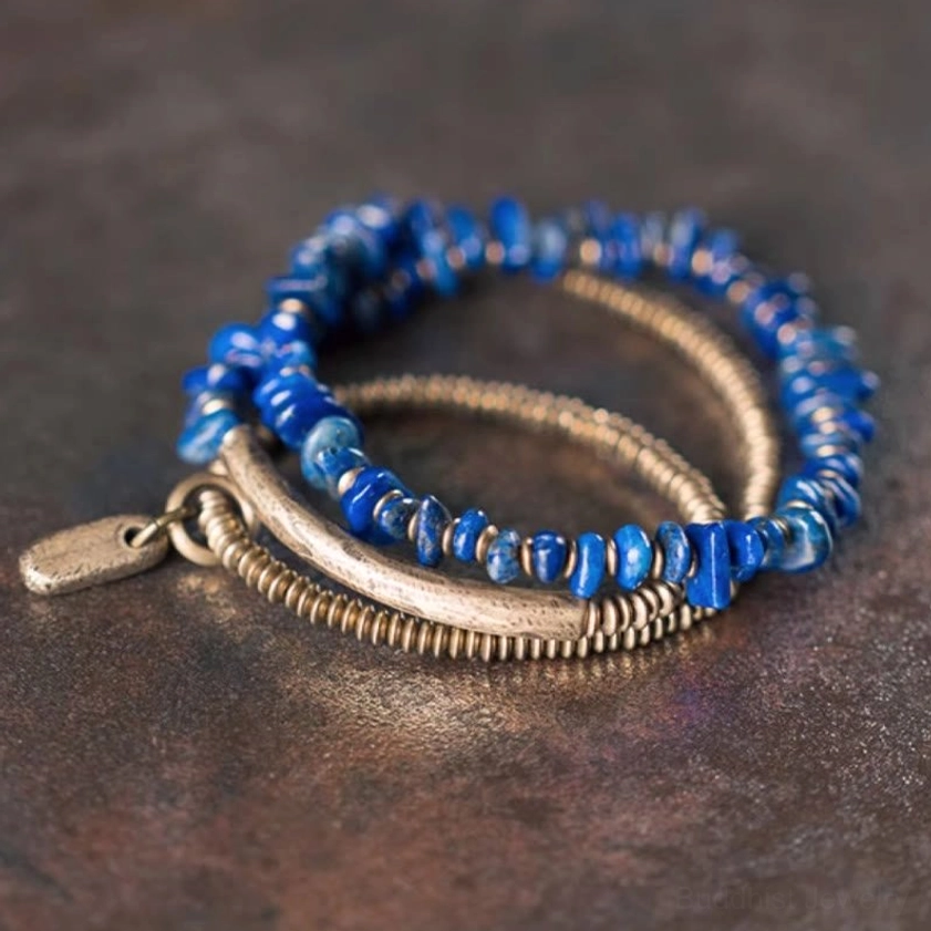 Top-down view of lapis lazuli wrapped bracelet showing layered three-strand design with metal charm, spiritual balance bracelet