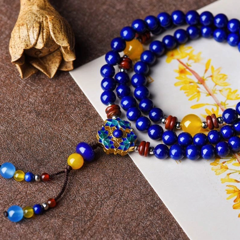 Authentic handmade Lapis Lazuli and Yellow Agate Buddhist mala bracelet with enamel flower pendant and mixed gemstone beads, overhead flat lay