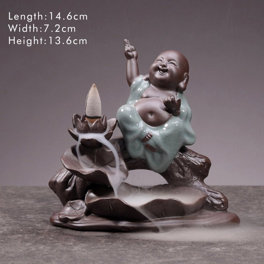 Happy Laughing Buddha ceramic backflow incense burner, left three-quarter shooting perspective, indoor tabletop display, brown ceramic base with celadon-glazed robes and flowing smoke