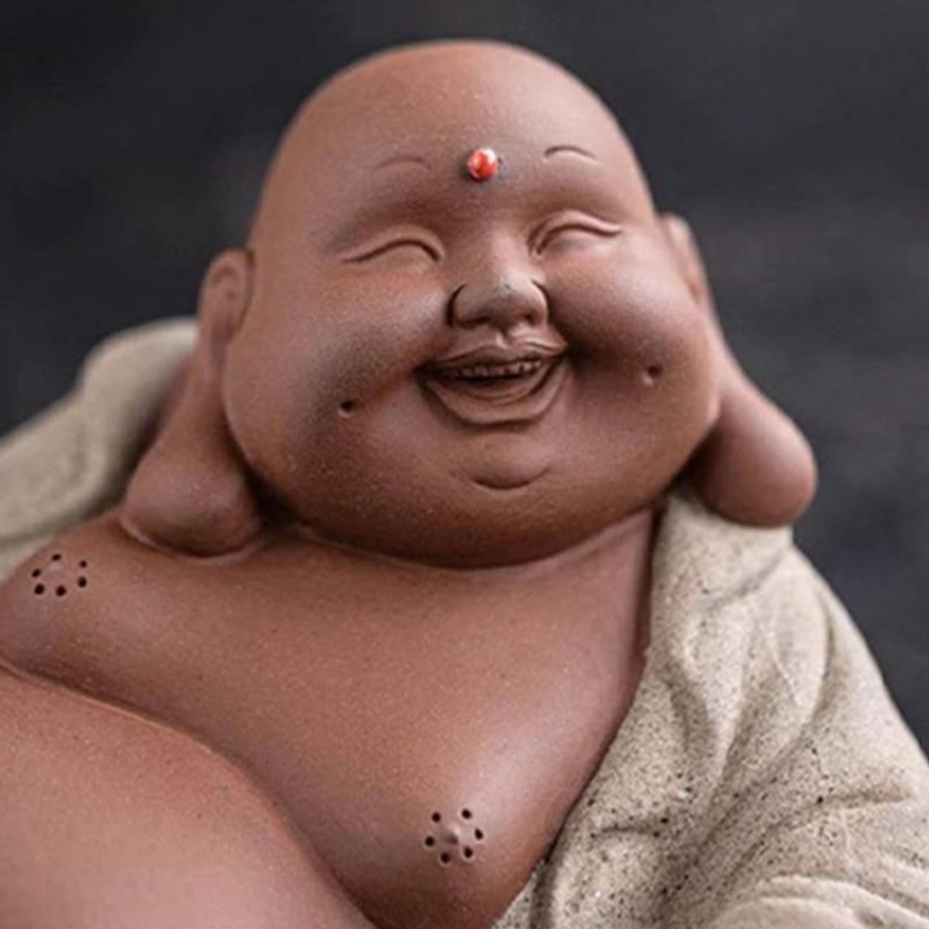 Close-up detailed view of Laughing Buddha face, red forehead dot, clay texture, peaceful expression, spiritual focal point