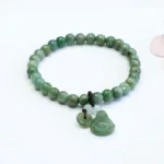 Laughing Buddha Cyan Jade bracelet with hand-carved Buddha charm and 6mm round green jade beads on premium elastic string, overhead flat lay view
