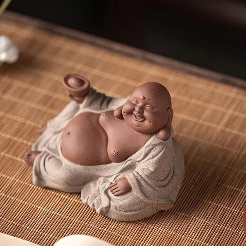 Laughing Buddha purple clay statue positioned in feng shui space, wealth and happiness focal point, spiritual décor