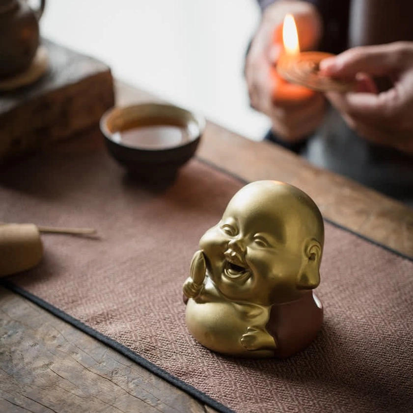 Laughing Buddha ceramic incense burner showing smiling face expression and perforated head design, handcrafted two-tone ceramic