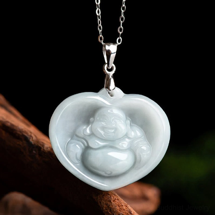 Heart-shaped white jade laughing Buddha pendant with silver bail, front flat lay view