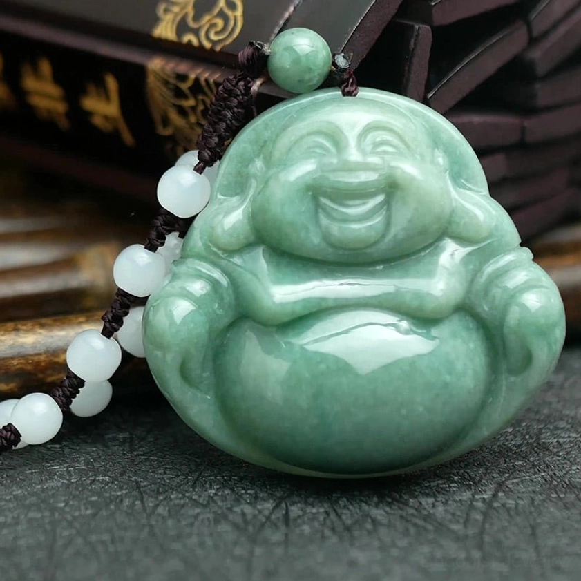 Handcrafted cyan jade Buddhist pendant with white beaded brown cord on vintage book backdrop