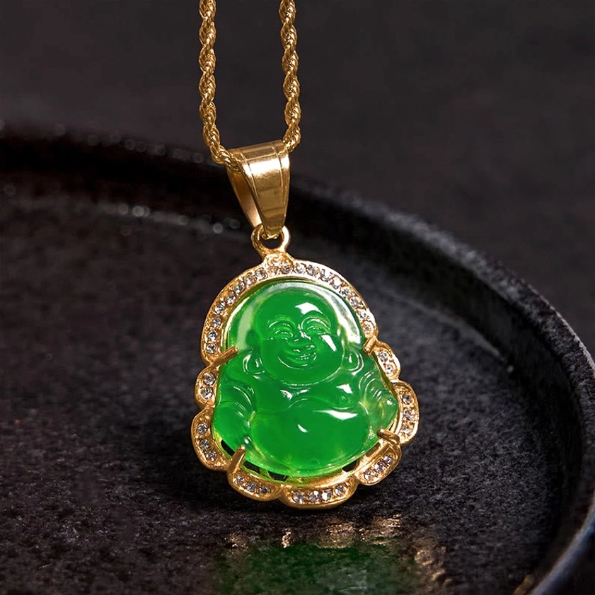 Close-up overhead view of Laughing Buddha jade necklace pendant on dark tray showing twisted gold chain and rhinestone-encrusted setting