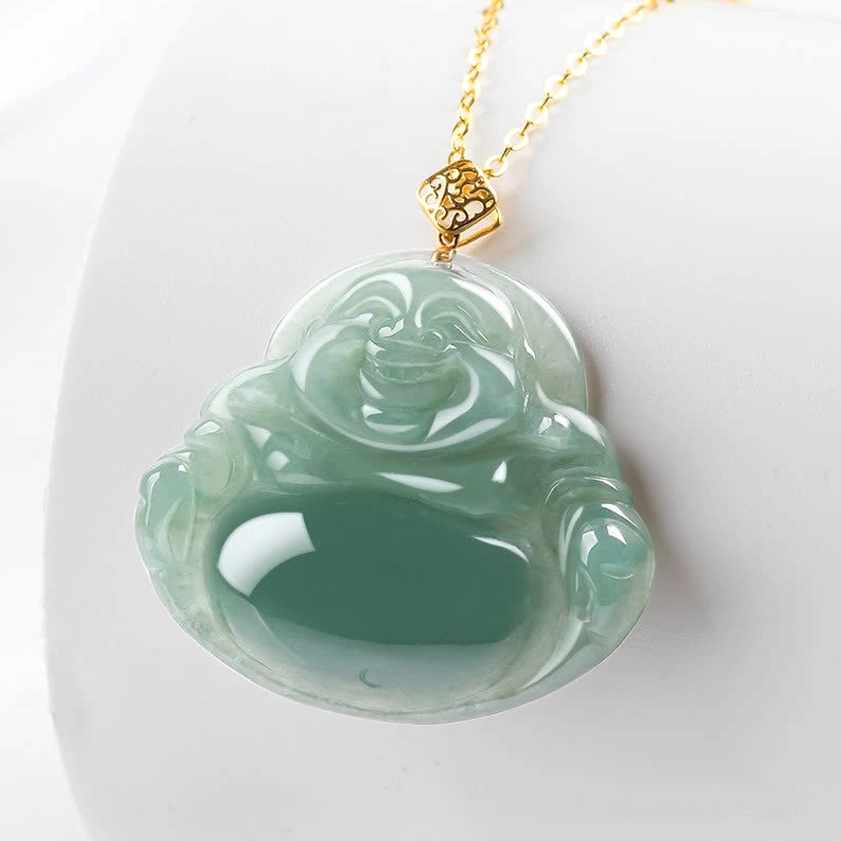 Laughing Buddha jade necklace with thin gold chain and square gold clasp on white ceramic display