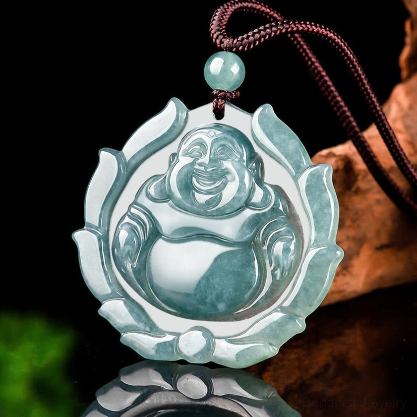 Hand-carved jade Buddha pendant with lotus pattern tilted angle shot on fabric display