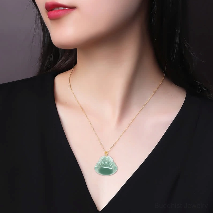 Woman wearing Laughing Buddha jade necklace close-up on neck with thin gold chain and black clothing