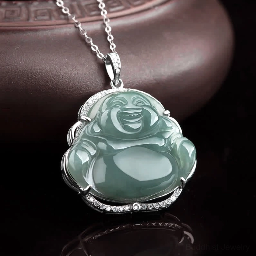 Polished green jade Buddha pendant with sparkling silver CZ crystal setting on dark wood background