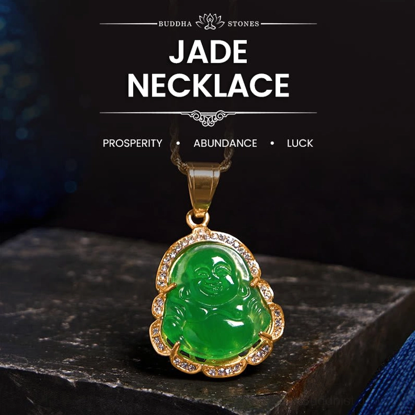 Green jade Laughing Buddha pendant with 18K gold-filled frame and rhinestone border, displayed on dark stone surface - top-down flat lay view
