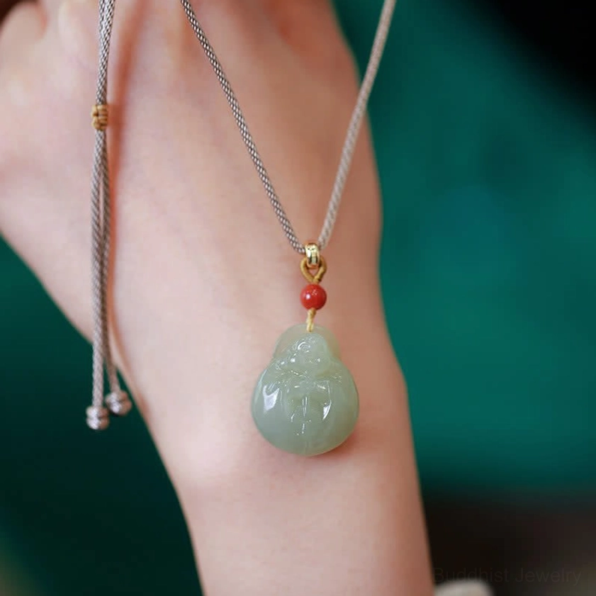 Hetian jade Buddha pendant necklace on back of hand showing rope adjustment ends and light green stone