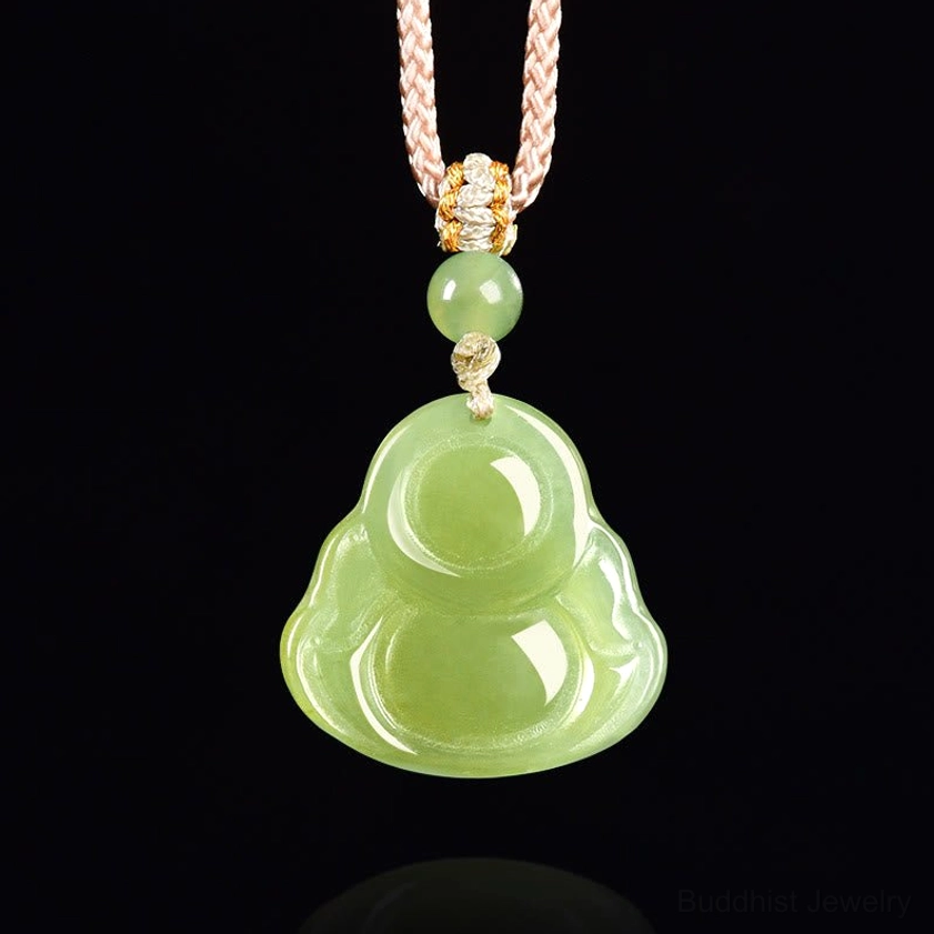 Full front view of green jade laughing Buddha necklace pendant, displaying the rounded Buddha carving and braided rope on pure black studio background