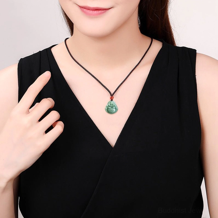 Woman wearing adjustable Laughing Buddha cyan jade necklace with brown cord and red accent bead on chest