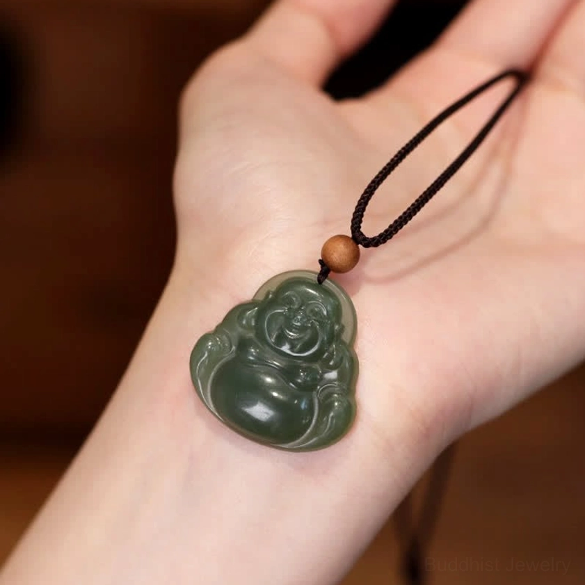 Laughing Buddha jade pendant necklace worn on wrist, showing intricate dark green carved Maitreya design with black cord and wooden spacer bead