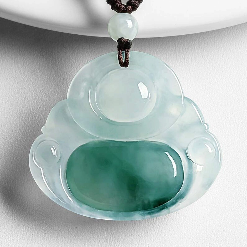 Cyan jade Buddhist necklace pendant showing translucent icy jade with dark green undertone, three-quarter view with brown waxed cord and decorative jade bead