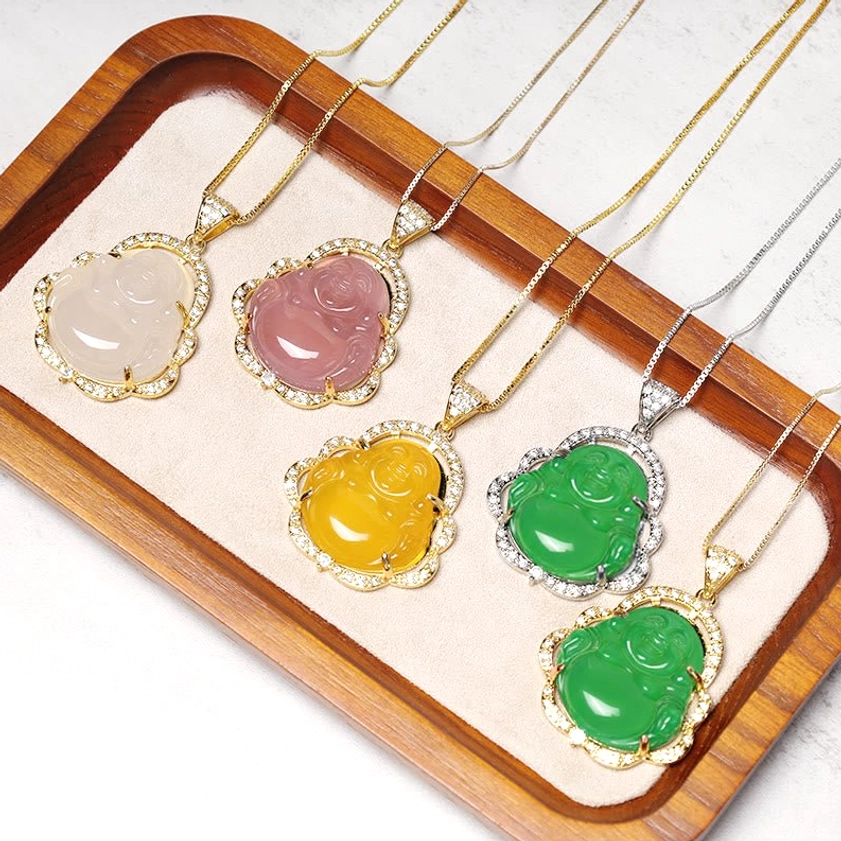 Mixed laughing Buddha necklace styles with gold and silver chains on wooden tray, retail display arrangement