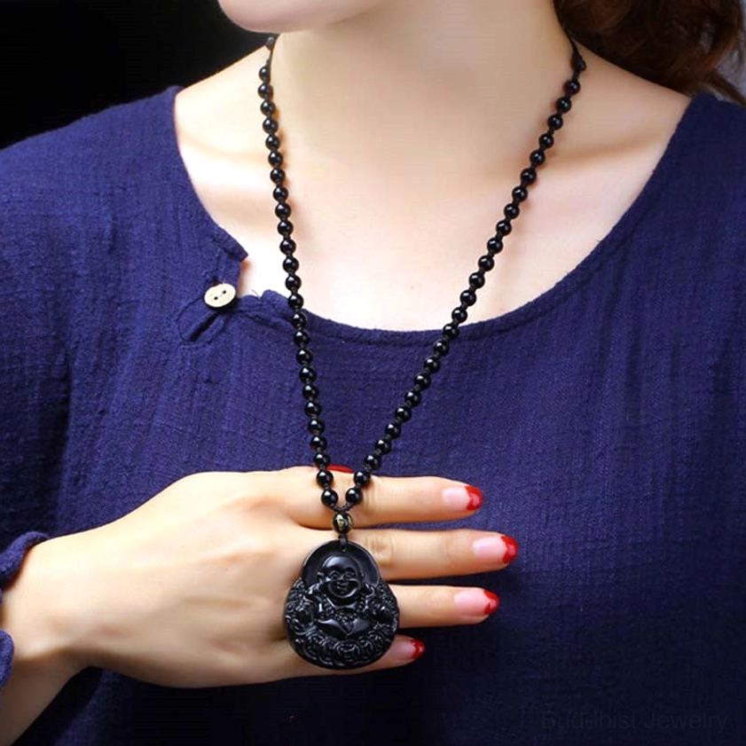 Black obsidian laughing Buddha necklace worn on body - daily wear close-up with navy top showing wearable jewelry
