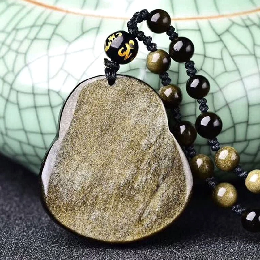 Back view of gold sheen obsidian Buddha pendant showing smooth flat back surface with celadon ceramic decor and beaded chain