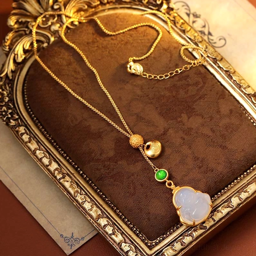 Laughing Buddha copper and chalcedony necklace flat lay on ornate vintage fabric tray, featuring loose gold chain, matching charm set, and green accent stone with Fu character tag